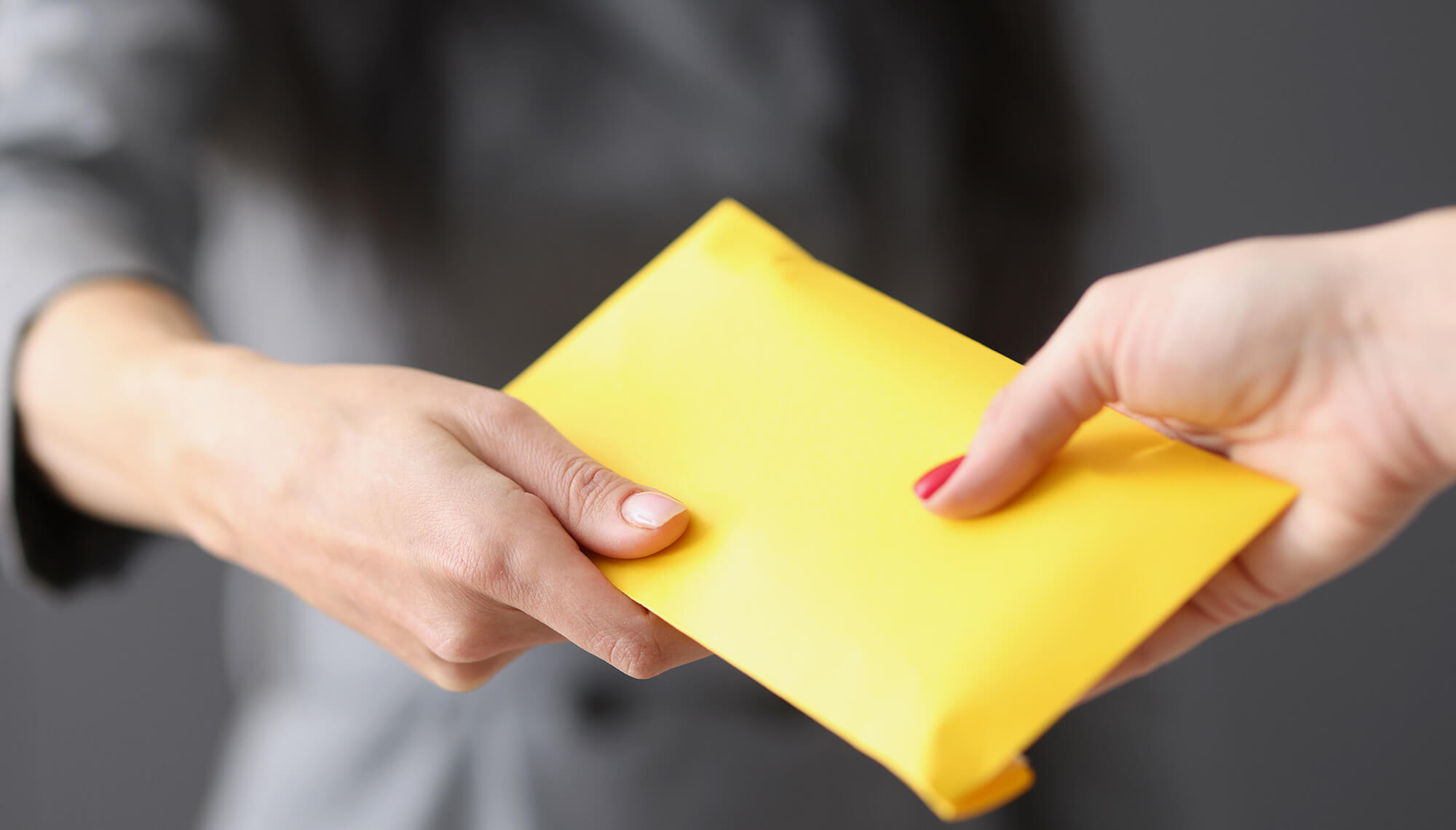 persona che consegna una busta a un'altra persona