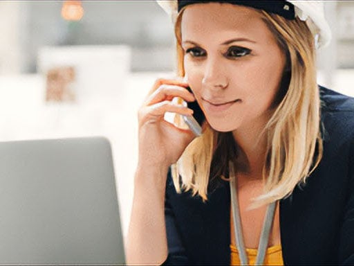 una donna con un elmetto di sicurezza che parla al telefono